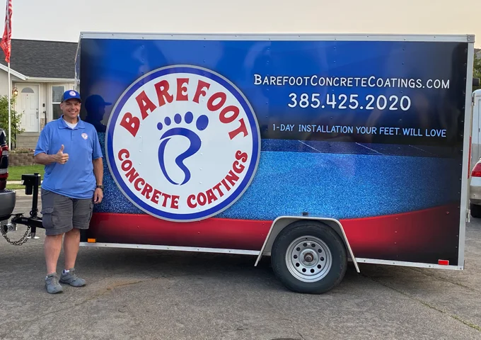 A large fleet from Barefoot Concrete Coating and Brian, the owner, posing on the side and giving a thumbs-up.