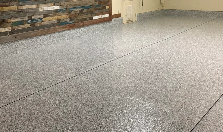 A fully coated and polished concrete floor with a bricked wall.