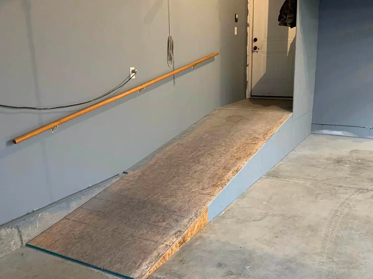 A before photo of an unkempt concrete ramp in a garage.