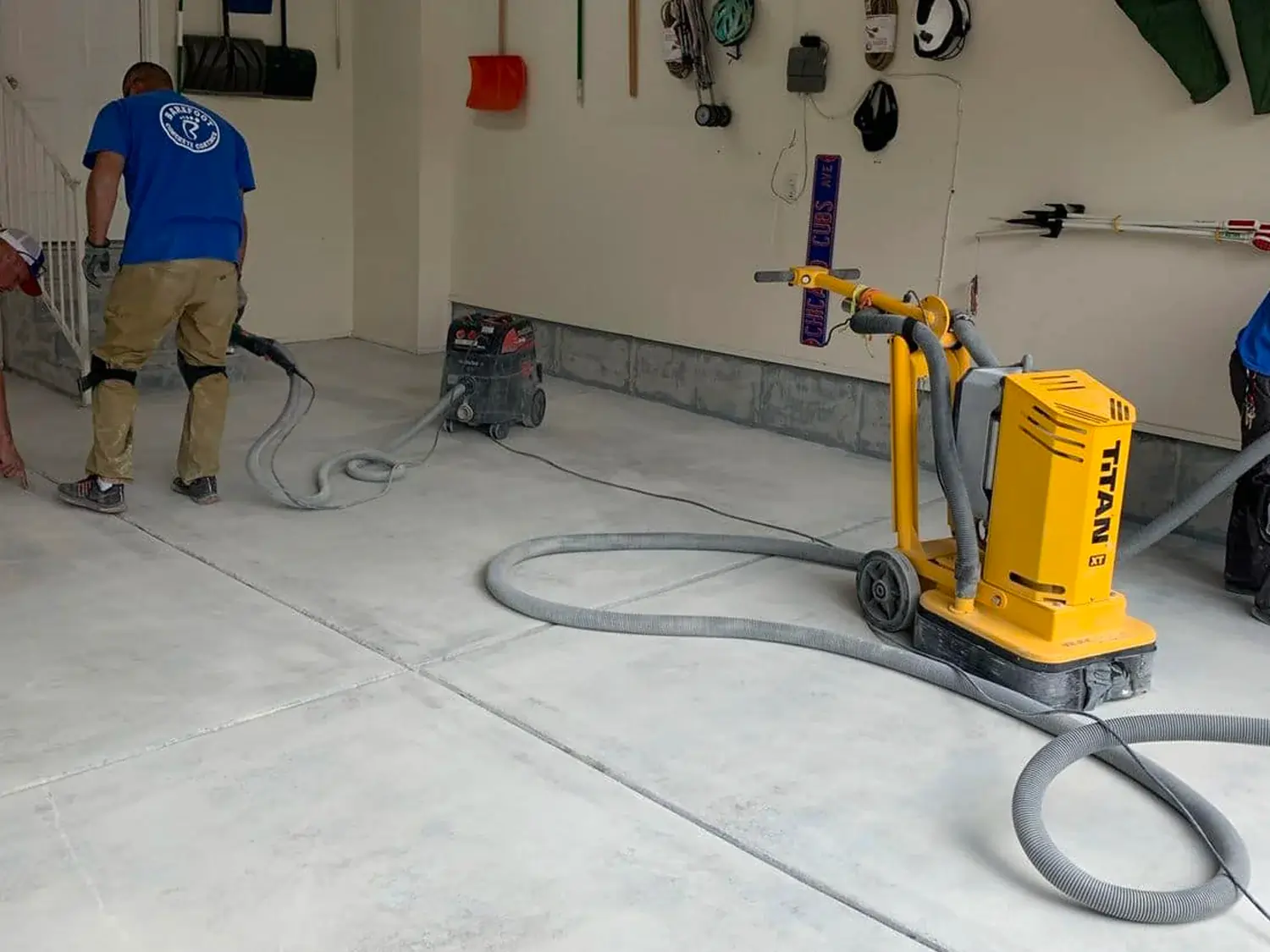 A professional working on a concrete floor in the garage using an equipment.
