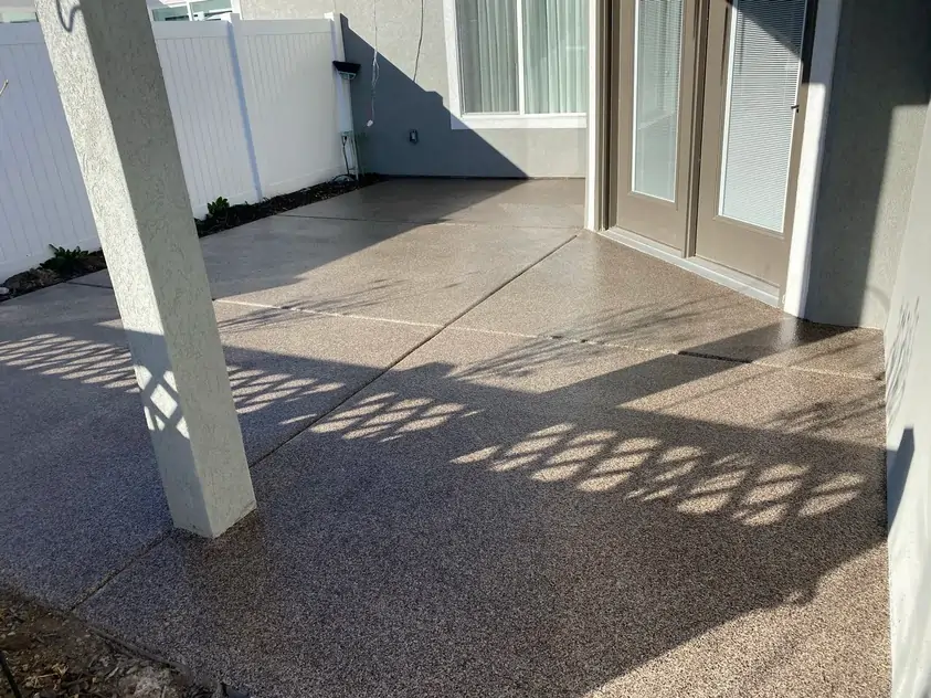 An after photo of a professionally coated and polished concrete floor with a gray door.