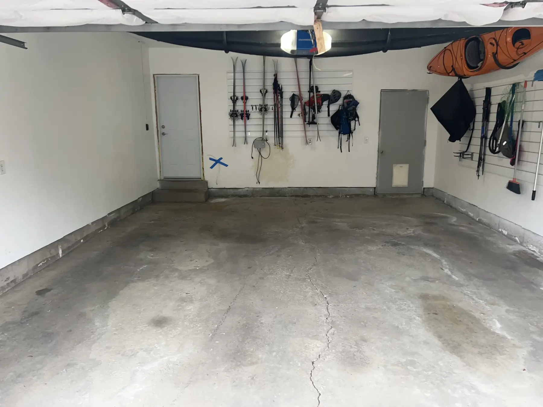 A white equipment storage room with an unpolished concrete floor.