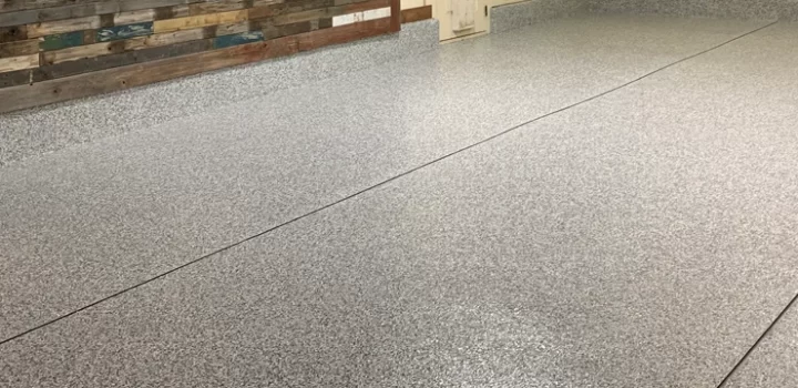 A fully coated and polished concrete floor with a bricked wall.